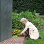 Frau Harms-Kranich legt eine Blumengesteck am Mahnmal nieder